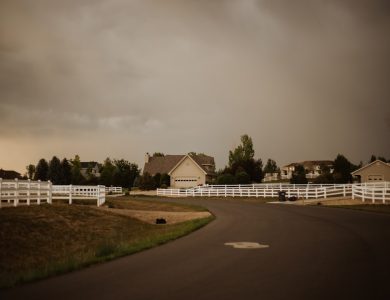 a road with white fences and houses