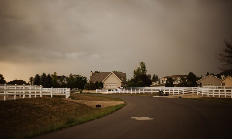 a road with white fences and houses