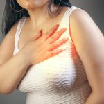 Woman holding her chest with a hand