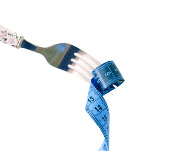 A fork twirls a blue measuring tape, symbolizing weight management and health.