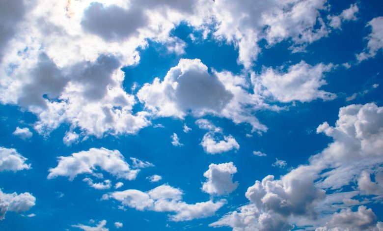 Vivid blue sky filled with fluffy white clouds, perfect for backgrounds.