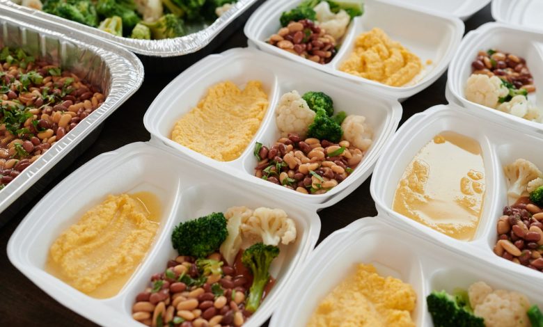 Assorted meal prep containers with beans, broccoli, and mashed potatoes, perfect for healthy eating.