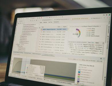 A close-up view of a laptop screen showing a coding and data analysis software interface in an indoor setting.