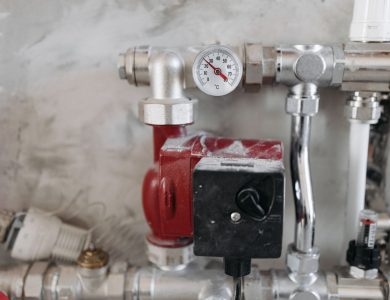 Close-up view of an industrial plumbing system featuring a pressure gauge and steel pipes.
