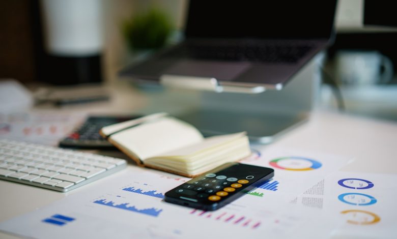 office desk with smartphone and financial charts