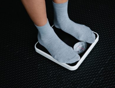 Close-up of feet in socks standing on a scale, focusing on weight measurement.