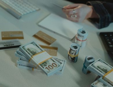 Close-up of dollar bills and credit cards on a desk, symbolizing financial transactions.