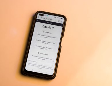 Smartphone showing ChatGPT website with warm tone, highlighting AI technology.