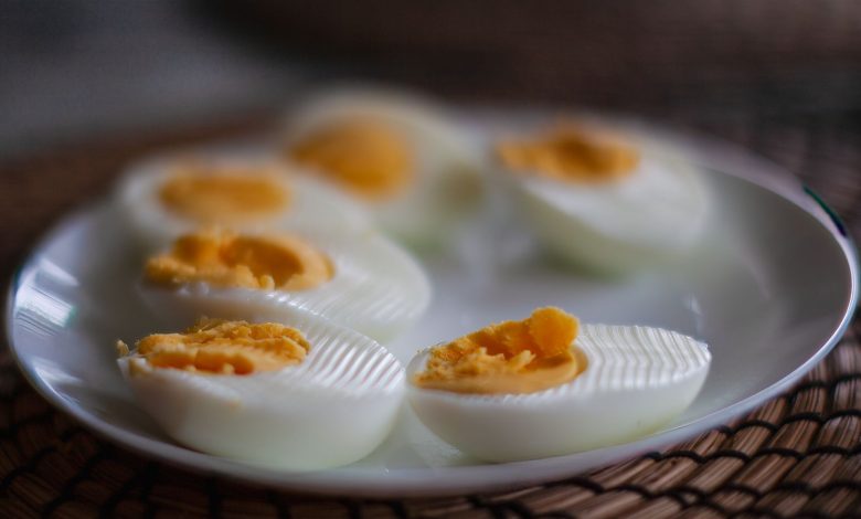 Close-up of sliced boiled eggs with soft yolks on a white plate, perfect breakfast or snack idea.