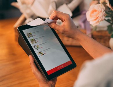 Hands using tablet for cashless payment, showcasing modern technology in retail.