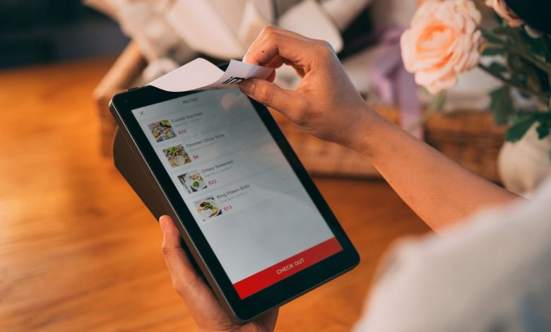 Hands using tablet for cashless payment, showcasing modern technology in retail.