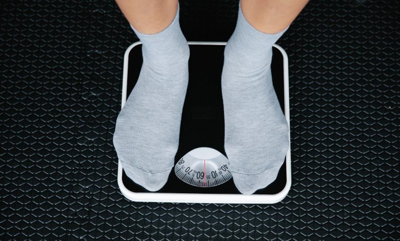 Top view of feet in socks standing on a bathroom scale, indicating weight measurement.